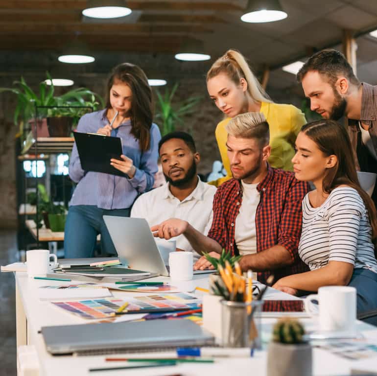 agency coworkers discussing project on laptop